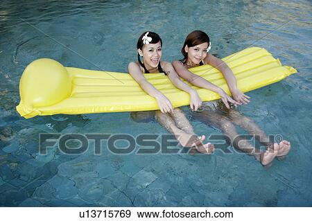 Two teenage girls with float in swimming pool. View Large Photo Image Stock Photo - Two teenage girls with float in swimming pool.. Fotosearch