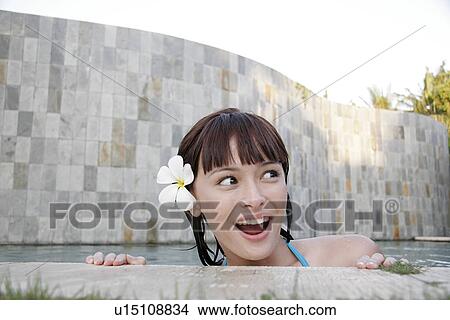 Picture - View of a teenage girl leaning near swimming pool.. Fotosearch