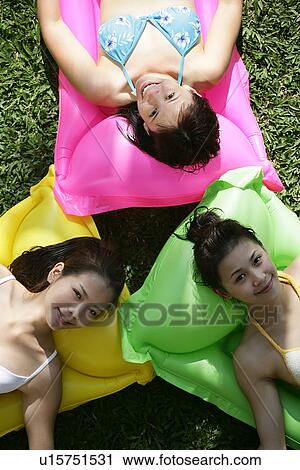 View of three teenage girls lying on floats. View Large Photo Image Stock Image - View of three teenage girls lying on floats.. Fotosearch