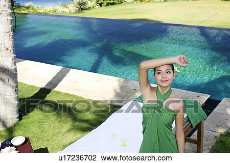 Stock Image - Front view of a teenage girl looking up.. Fotosearch