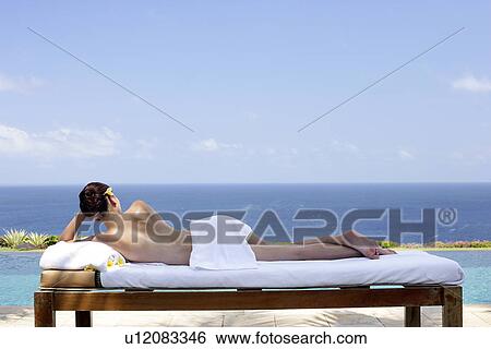 Rear view of a teenage girl sun bathing. View Large Photo Image Stock Photograph - Rear view of a teenage girl sun bathing.. Fotosearch