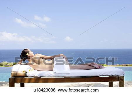 Stock Photograph - Rear view of teenage girl sun bathing.. Fotosearch