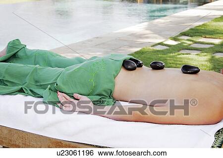 View of a female undergoing a hot stone therapy. View Large Photo Image Stock Photograph - View of a female undergoing a hot stone therapy.. Fotosearch
