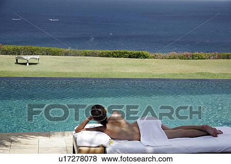 View of a seminude teenage girl lying near a swimming pool. View Large Photo Image Stock Photo - View of a seminude teenage girl lying near a swimming pool.. Fotosearch