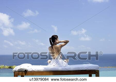 View of a seminude teenage girl on a bed against the sea. View Large Photo Image Picture - View of a seminude teenage girl on a bed against the sea.. Fotosearch