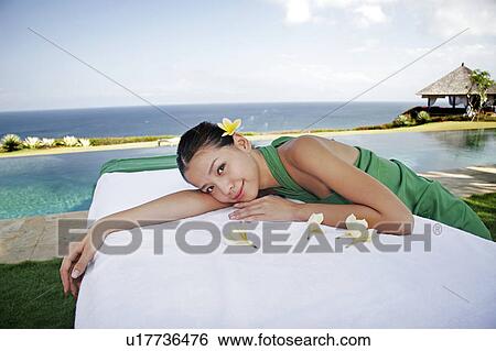 Stock Photograph - View of a teenage girl leaning on a bed.. Fotosearch