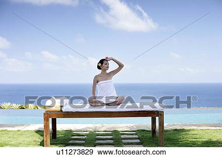 View of a teenage girl sitting on a bed. View Large Photo Image Stock Photo - View of a teenage girl sitting on a bed.. Fotosearch