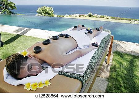 View of a teenage girl undergoing a hot stone therapy. View Large Photo Image Picture - View of a teenage girl undergoing a hot stone therapy.. Fotosearch