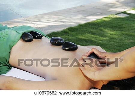 View of a teenage girl undergoing a hot stone therapy. View Large Photo Image Stock Image - View of a teenage girl undergoing a hot stone therapy.. Fotosearch
