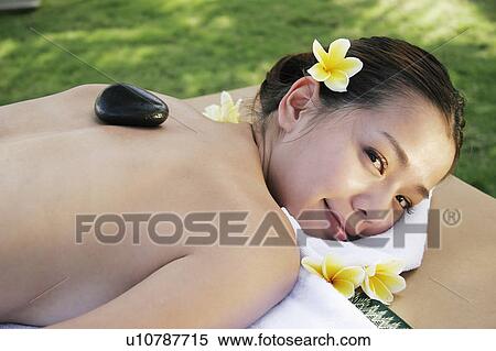 Stock Photography - View of a teenage girl with a stone on her back.. Fotosearch