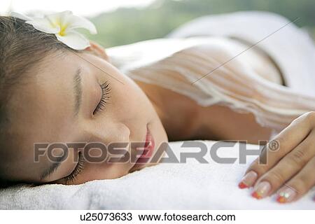 Stock Image - View of a teenage girl with cream on her back.. Fotosearch