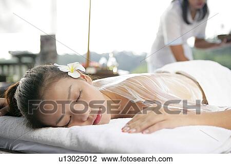 Stock Image - View of a teenage girl with cream application on her back.. Fotosearch