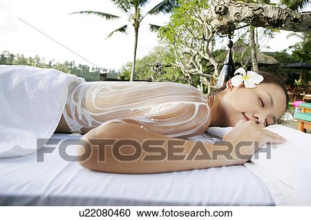 Stock Image - View of a teenage girl with cream application on her back.. Fotosearch