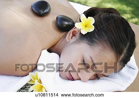 View of a teenage girl with stones on her back. View Large Photo Image Picture - View of a teenage girl with stones on her back.. Fotosearch