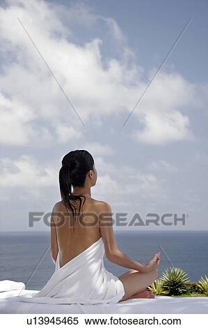 Stock Photography - View of a teenage girl in lotus position.. Fotosearch