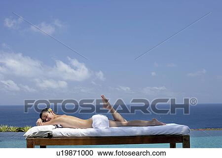 View of a teenage girl relaxing on a bed against the sea. View Large Photo Image Stock Image - View of a teenage girl relaxing on a bed against the sea.. Fotosearch