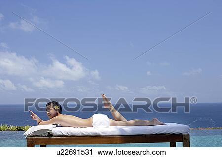 View of a teenage girl relaxing on a bed against the sea. View Large Photo Image Stock Image - View of a teenage girl relaxing on a bed against the sea.. Fotosearch
