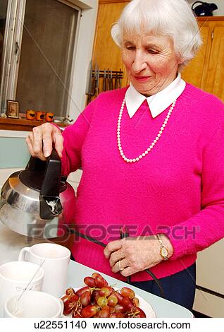 A elderly woman pouring tea in mugs. View Large Photo Image Stock Image - A elderly woman pouring tea in mugs.. Fotosearch
