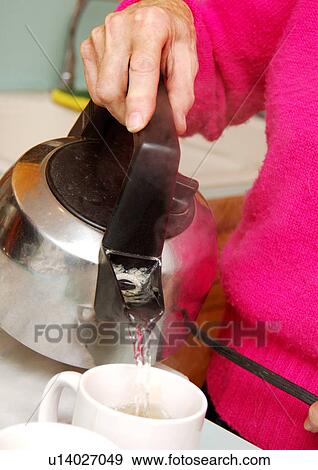 A woman is pouring water in a teacup. View Large Photo Image Stock Photo - A woman is pouring water in a teacup.. Fotosearch