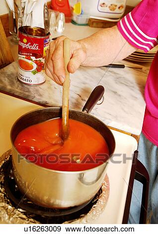 Stock Photo - A woman is preparing tomato puree.. Fotosearch