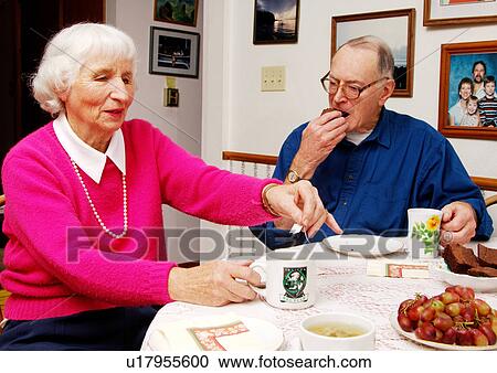 Stock Image - An elderly couple at the breakfast table.. Fotosearch