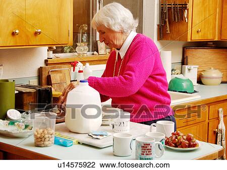 An elderly woman is working in a kitchen. View Large Photo Image Stock Image - An elderly woman is working in a kitchen.. Fotosearch