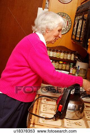 An elderly woman is working in the kitchen. View Large Photo Image Stock Image - An elderly woman is working in the kitchen.. Fotosearch