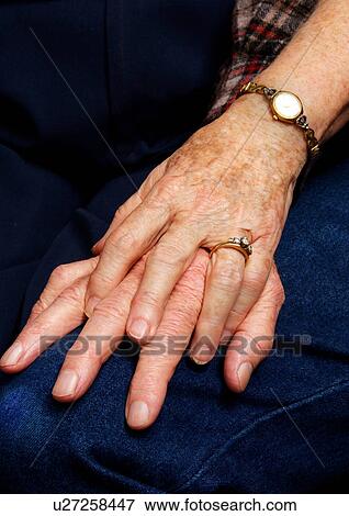 Stock Photo - Close-up of a couples clasped hands.. Fotosearch