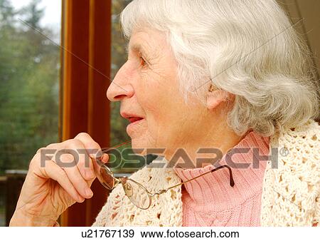 Close-up of a senior woman absorbed in her thoughts. View Large Photo Image Stock Photo - Close-up of a senior woman absorbed in her thoughts.. Fotosearch