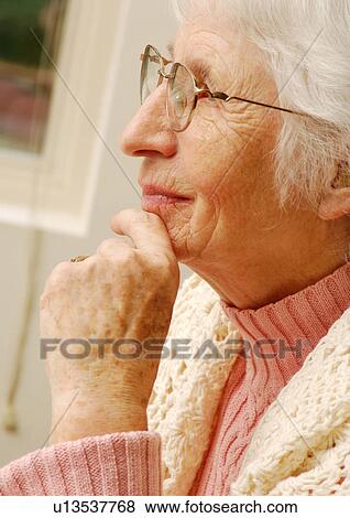 Close-up of an elderly woman absorbed in her thoughts. View Large Photo Image Stock Photo - Close-up of an elderly woman absorbed in her thoughts.. Fotosearch