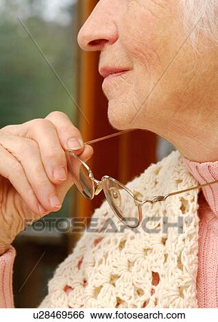 Close-up of glasses held by an elderly woman. View Large Photo Image Stock Photograph - Close-up of glasses held by an elderly woman.. Fotosearch