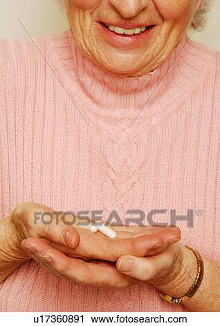 Midsection of a woman holding some capsules. View Large Photo Image Stock Image - Midsection of a woman holding some capsules.. Fotosearch