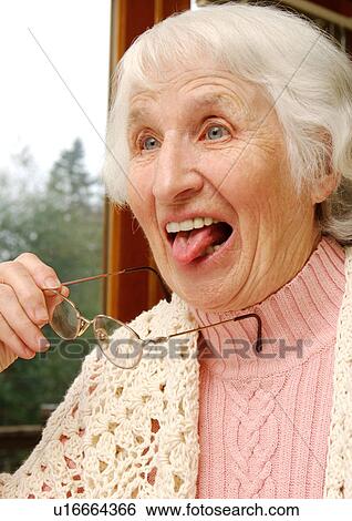 Stock Photograph - Portrait of an elderly woman acting childishly.. Fotosearch