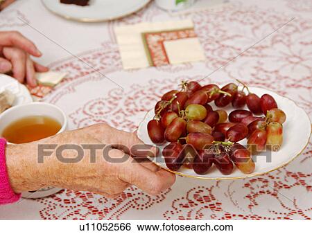 View of grapes on a plate held by a woman. View Large Photo Image Stock Photograph - View of grapes on a plate held by a woman.. Fotosearch