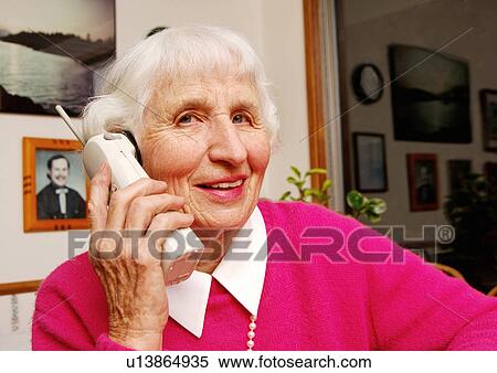 An elderly woman conversing on a cell phone. View Large Photo Image Stock Photography - An elderly woman conversing on a cell phone.. Fotosearch