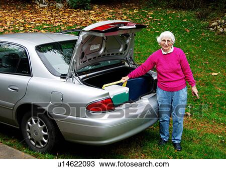 An elderly woman picking her bag from the trunk of her car. View Large Photo Image Stock Image - An elderly woman picking her bag from the trunk of her car.. Fotosearch