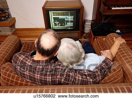 Stock Image - High angle view of an elderly couple watching television.. Fotosearch