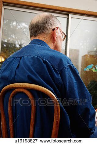 Rear view of an elderly man sitting on a chair. View Large Photo Image Stock Photo - Rear view of an elderly man sitting on a chair.. Fotosearch