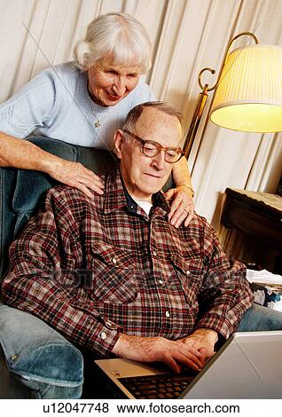 View of an elderly couple surfing on their laptop. View Large Photo Image Stock Photo - View of an elderly couple surfing on their laptop.. Fotosearch