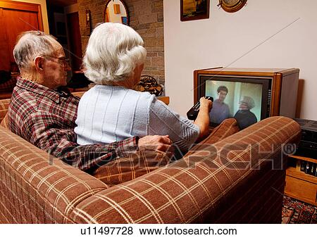 Stock Photo - View of an elderly couple watching television.. Fotosearch