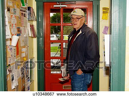 Stock Photo - View of an elderly man standing near a notice board.. Fotosearch