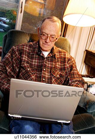 View of an elderly man surfing on his laptop. View Large Photo Image Stock Photograph - View of an elderly man surfing on his laptop.. Fotosearch