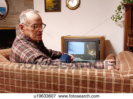 View of an elderly man watching resting on a couch. View Large Photo Image Stock Photo - View of an elderly man watching resting on a couch.. Fotosearch
