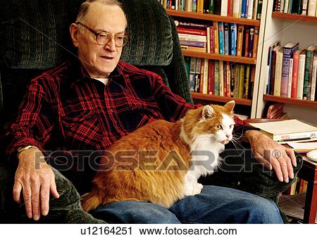 Stock Image - View of an elderly man with his pet cat.. Fotosearch