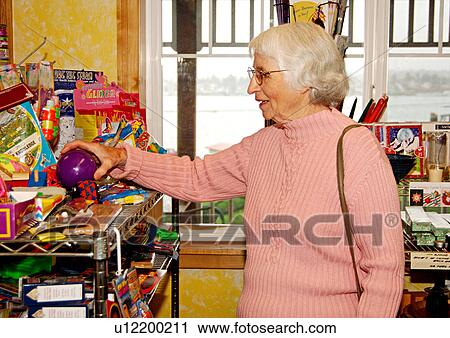 View of an elderly woman checking out the displayed products. View Large Photo Image Stock Image - View of an elderly woman checking out the displayed products.. Fotosearch