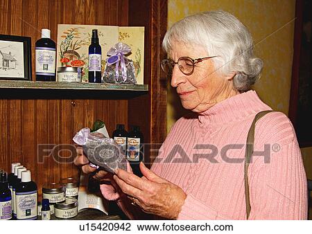View of an elderly woman checking out the displayed products. View Large Photo Image Stock Image - View of an elderly woman checking out the displayed products.. Fotosearch