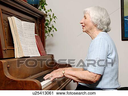 View of an elderly woman playing a piano. View Large Photo Image Stock Image - View of an elderly woman playing a piano.. Fotosearch