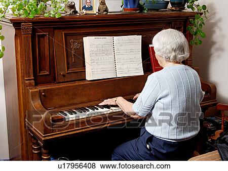 View of an elderly woman playing a piano. View Large Photo Image Stock Photo - View of an elderly woman playing a piano.. Fotosearch
