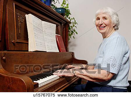 View of an elderly woman playing a piano. View Large Photo Image Stock Photography - View of an elderly woman playing a piano.. Fotosearch