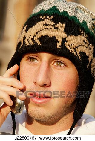Close-up of a young man conversing on his cell phone. View Large Photo Image Stock Photo - Close-up of a young man conversing on his cell phone.. Fotosearch